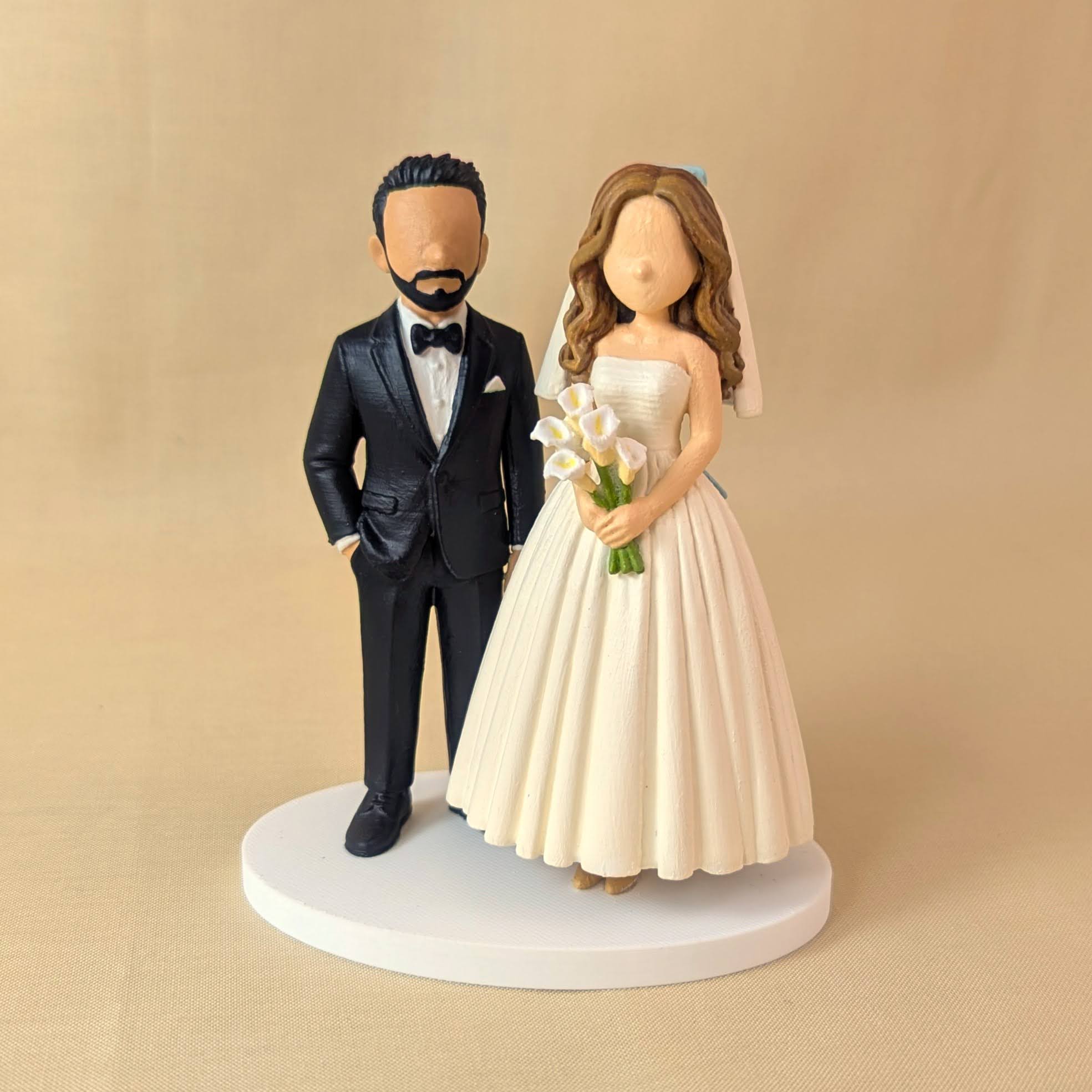 Personalized wedding cake topper with the groom in a black tuxedo and bride holding calla lilies